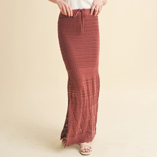 Woman wearing a white top and red patterned skirt on a beige background